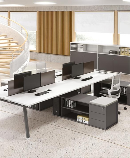 Bureau moderne en open space. Longs bureaux blancs, chaises ergonomiques, rangements gris. Escalier en colimaçon, mur bois, grandes fenêtres.