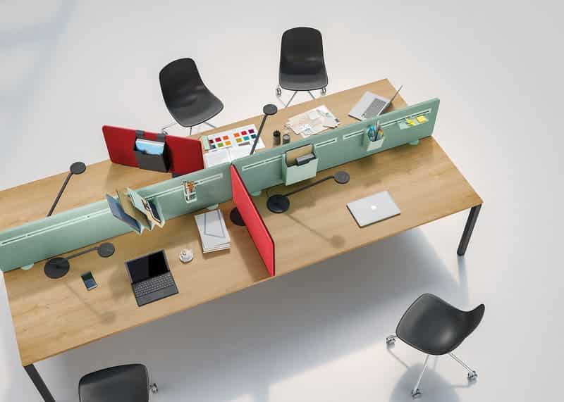 Bureau partagé moderne en bois clair avec séparateurs modulaires verts, rangements intégrés, ordinateurs portables et chaises noires.