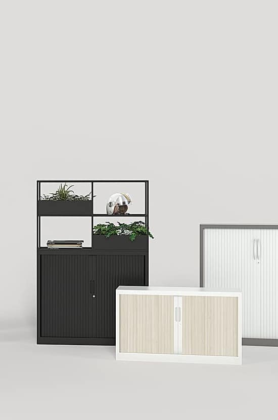 Mobilier de bureau avec armoire de rangement noire à rideaux, étagères avec plantes et décorations, et deux meubles bas à rideaux blanc et bois clair.