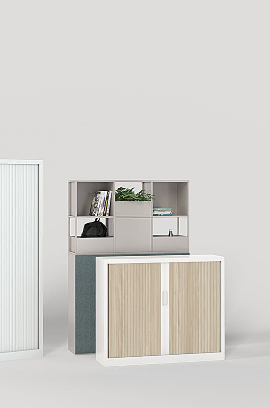 Mobilier de bureau moderne: étagère modulaire grise avec livres et plante, armoire à rideaux bois clair et meuble de rangement cannelé blanc.