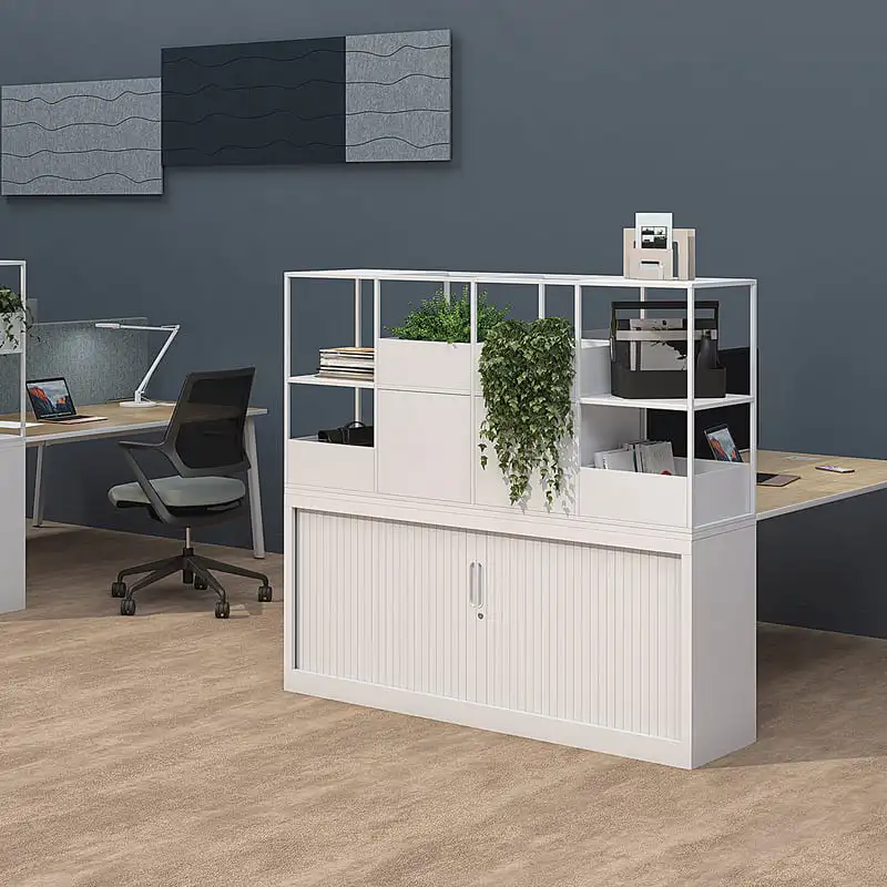 Unité de rangement de bureau blanche avec étagères ouvertes, plantes vertes et placard à rideau. Bureaux, chaise et panneaux acoustiques gris.