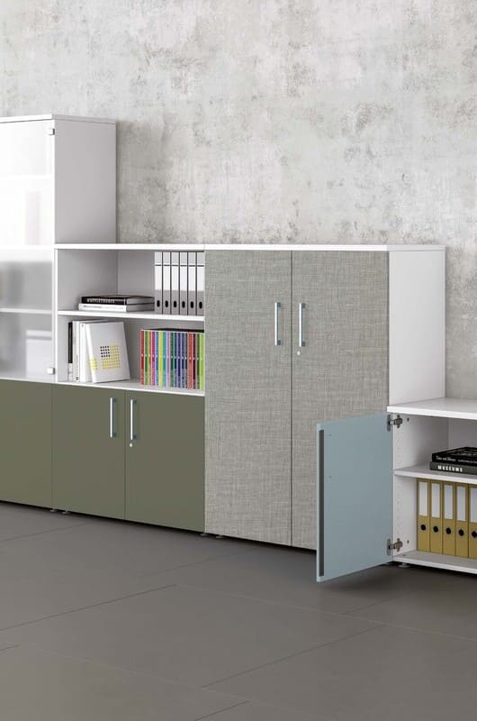 Système de rangement de bureau modulaire blanc, gris texturé et vert olive avec étagères ouvertes et fermées, remplies de classeurs et livres.